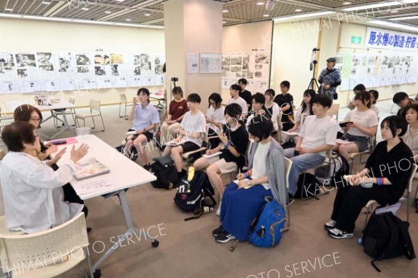 講話に耳を傾けるツアーメンバー