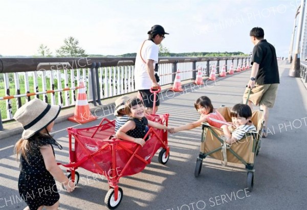 打ち上げ時刻まであと２時間半。橋の上で散歩する親子連れ。楽ちんな移動に子どもたちはニコニコ