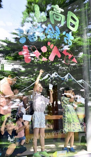 クレヨンで窓ガラスに日高山脈の動植物を描く子どもたち（１２日、塩原真撮影）