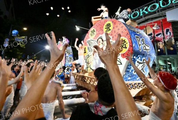 みこしの上からパンをまく担ぎ手（１４日、塩原真撮影）