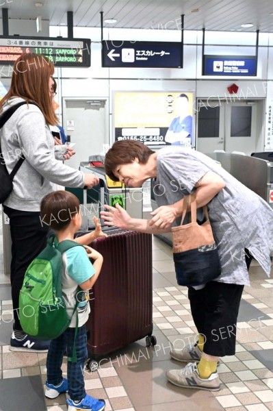 改札口で、親類との別れを惜しむ帰省客（１７日午前１１時ごろ、ＪＲ帯広駅で。須貝拓也撮影）