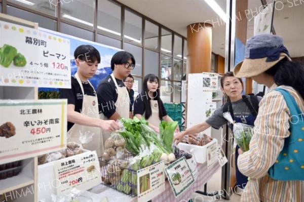 空港に訪れた観光客らに十勝産野菜などを販売する生徒たち（１７日午前９時半ごろ）