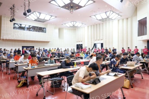 競技者全員が集まって競技内容や気象条件を競技役員から聞く「タスクブリーフィング」。真剣に地図などの資料に見入る（助川かおる通信員撮影）