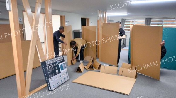 「しおさい荘」で簡易ベッドを組み立てる音調津自主防災会の住民ら（３０日午後５時２０分ごろ）