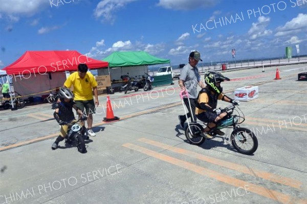 補助バー付きの電動バイクを体験する子供たち。すぐに乗れるようになった（１３日）