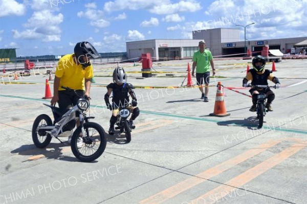 スタッフの指導を受け、電動バイクでコースを走行する子供たち（１３日）