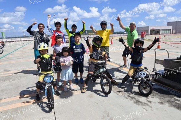電動バイク体験後、スタッフらと記念撮影する子供たち（１３日）