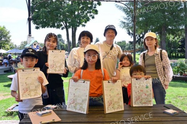 描いた絵を手にする親子連れ