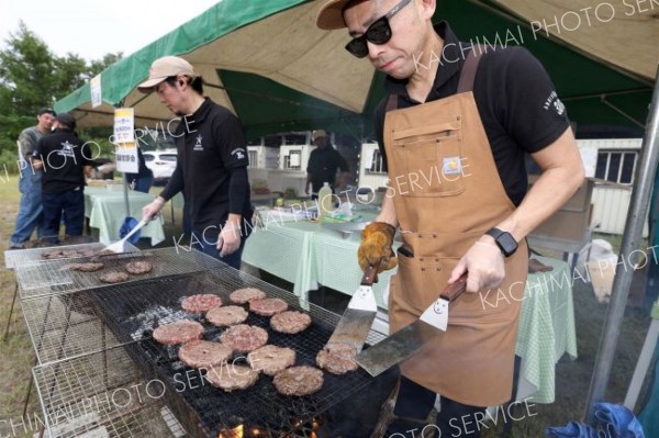 おいしそうなハンバーグを焼き上げる飲食の出店（３１日午前１０時２０分ごろ、助川かおる通信員撮影）