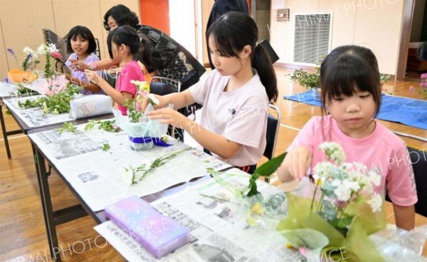 色合いやバランスを考えながら花を生ける児童