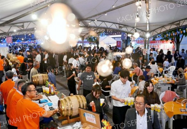 明かりで装飾された会場で飲食する来場客