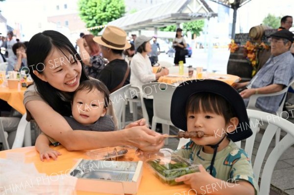 特設テントで地元グルメを味わう来場者（６日午前１０時５０分ごろ、駅北口広場・須貝拓也撮影）