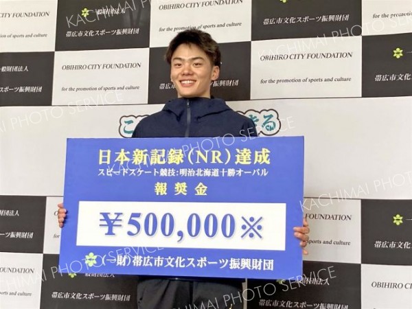 男子３０００メートルで日本新記録を達成し、報奨金のパネルを手にする