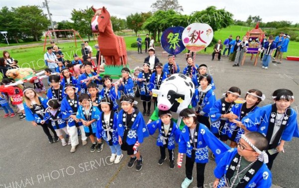 手作りした牛と馬のみこしを地域住民に披露した児童ら（７日）