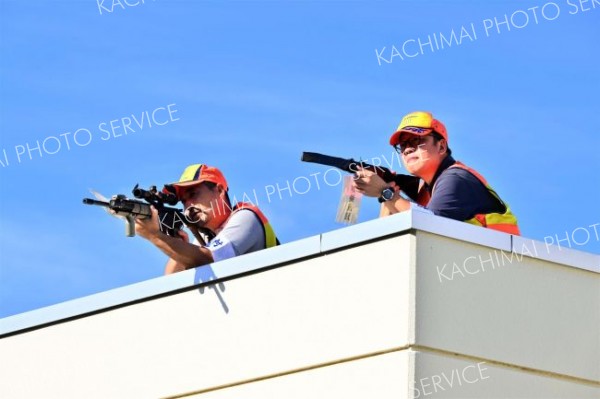 建物の上から猟銃を構えるハンター（金野和彦撮影）