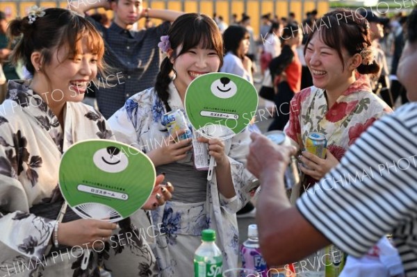 冷たーいー。勝毎花火大会の出店で冷えたドリンクを購入し、笑顔を輝かせる浴衣を着た来場者（１３日、十勝川河川敷特設会場で。須貝拓也撮影）