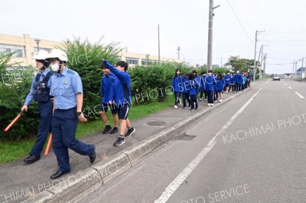 目的地に向けて集団で避難する生徒ら