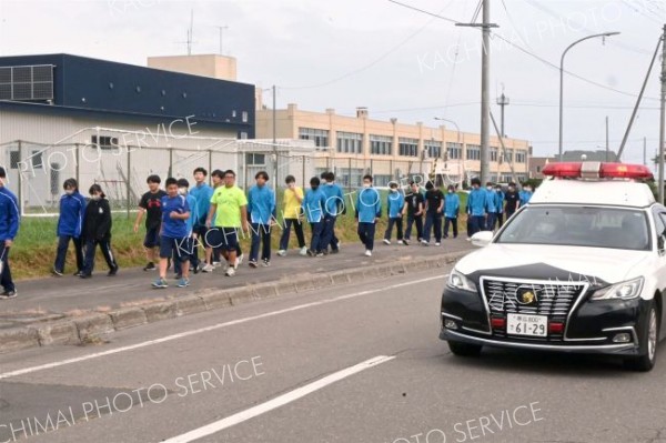目的地に向けて集団で避難する生徒ら