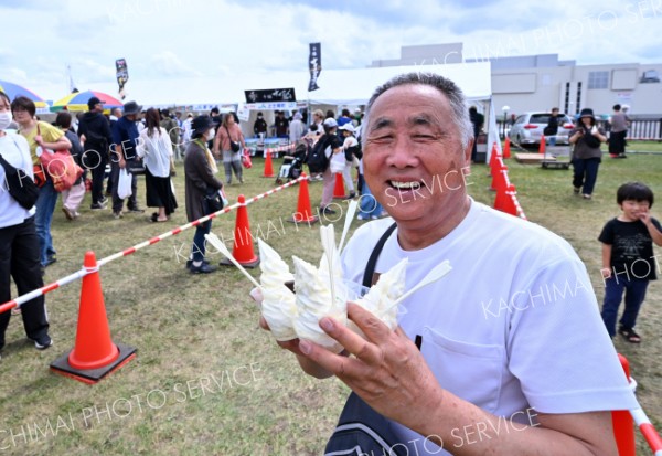 ４つのパフェを一度に買い求め笑顔の来場者（１３日、音更町のよつ葉ミルクフェスタで。塩原真撮影）