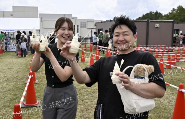 会場限定パフェのお味はー。「よつ葉の白いパフェミルクフェスタＶｅｒ.」を買い求める来場者（１３日、音更町のよつ葉ミルクフェスタで。塩原真撮影）