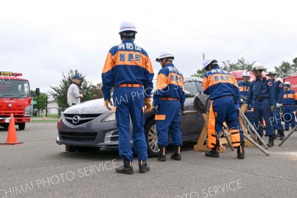 工事現場で鋼材の下敷きになった車両の中から負傷者を救出する訓練を行う参加者ら