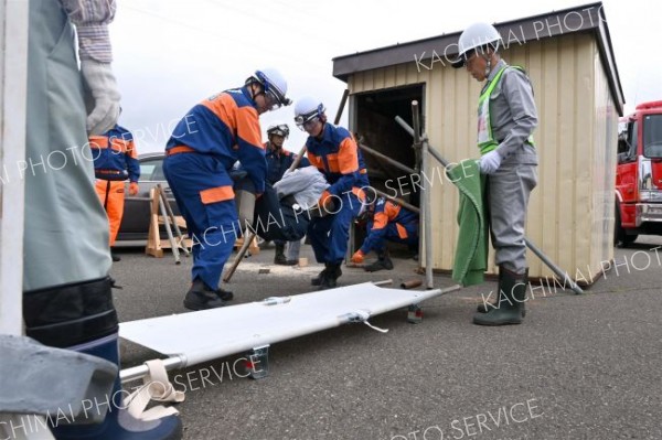 土砂崩れで倒壊して土に埋まった住宅の中から負傷者を救出する訓練に当たる参加者ら