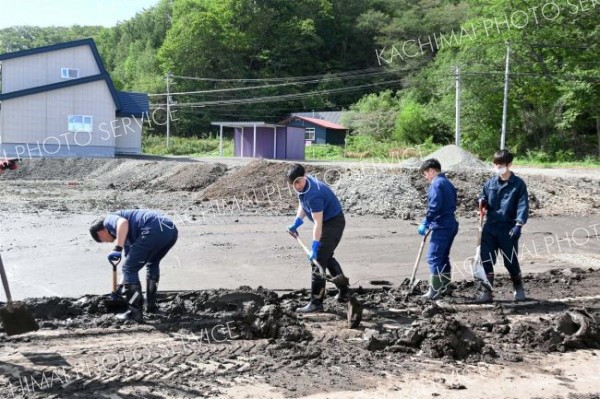 町道や歩道に溜まった汚泥をかき出す町職員