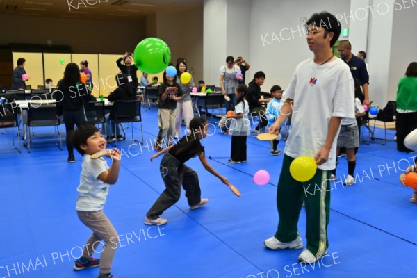 風船スマッシュ！ダンボールで作ったラケットで遊ぶ親子（２１日、「卓球Ｔリーグ帯広大会」のイベント、よつ葉アリーナ十勝で。金野和彦撮影）