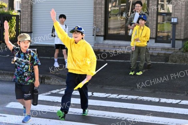 安全確認して歩行者と一緒に横断歩道を渡る団員