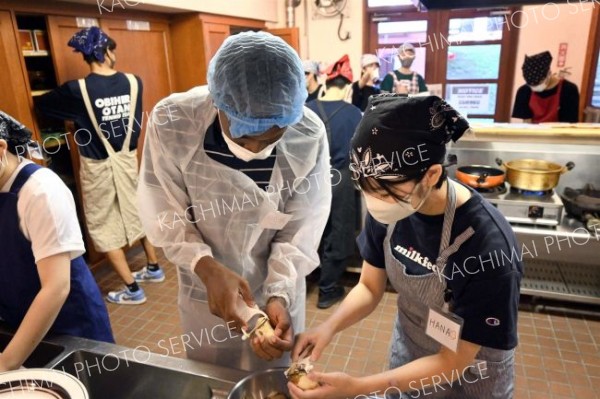 英語でコミュニケーションを取りながら、ジャガイモの皮をむく様子