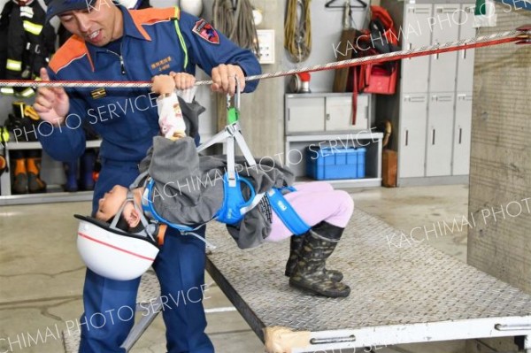 ロープにぶら下がって進む体験をする園児