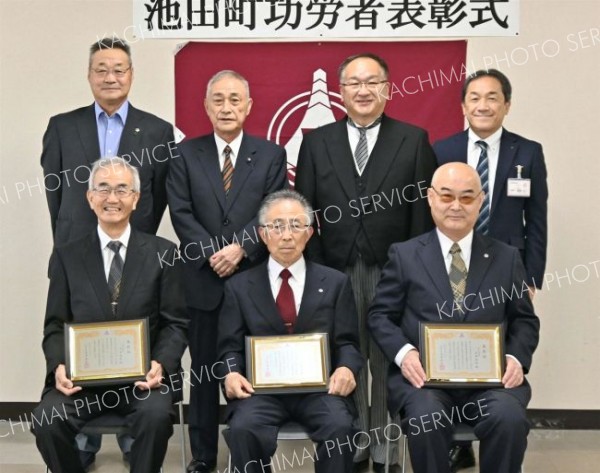 表彰状を手にする