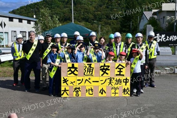 交通安全啓発に参加した大誉地小の児童と拓殖工業の職員ら