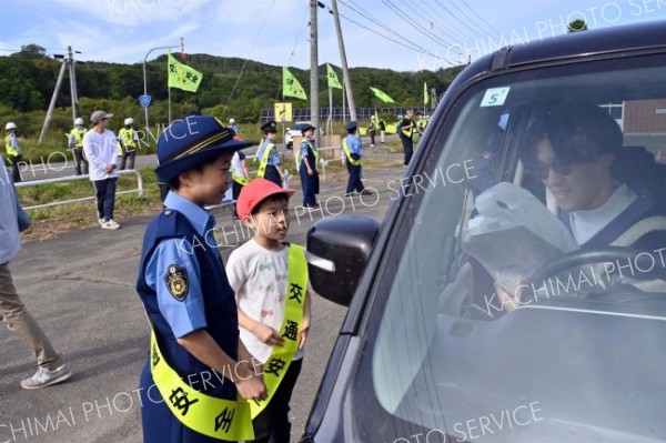 国道２４２号を通行するドライバーに安全運転を呼びかける大誉地小の児童