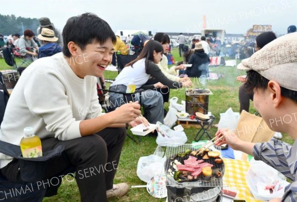 うまい！こんがり焼いたにんにくと牛肉に舌鼓を打ち、満面の笑顔を見せる来場者