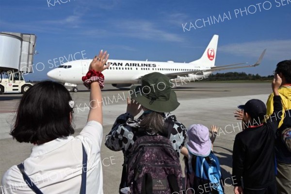 羽田空港行きの旅客機へ手を振るお見送り体験の参加者（須貝拓也撮影）