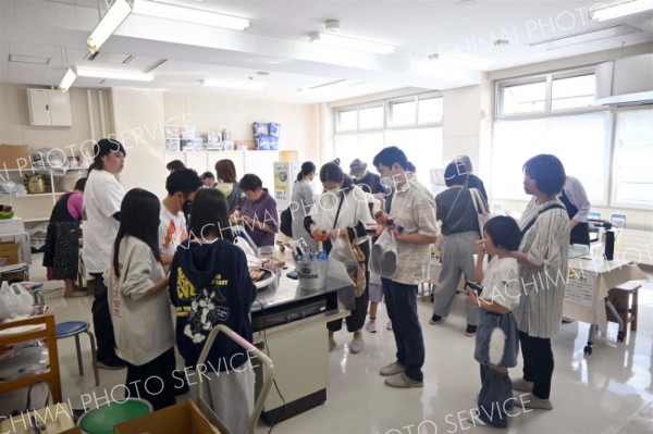 調理室の飲食コーナーで列をつくる来場者たち