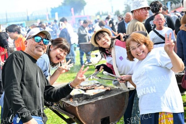 おいしいのはワインだけじゃない。牛肉にソーセージ、ハンバーグなどを楽しみ笑顔の来場者（５日、池田町秋のワイン祭りで、塩原真撮影）