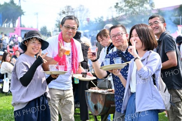 おいしい食事にワインも進む。コップを片手に「はいチーズ！」（５日、池田町秋のワイン祭りで、塩原真撮影）