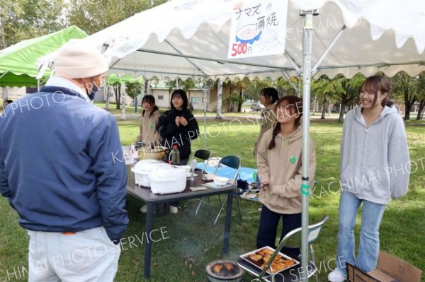 ナマズ料理を提供する「もりとも！」の学生たち（助川かおる通信員撮影）