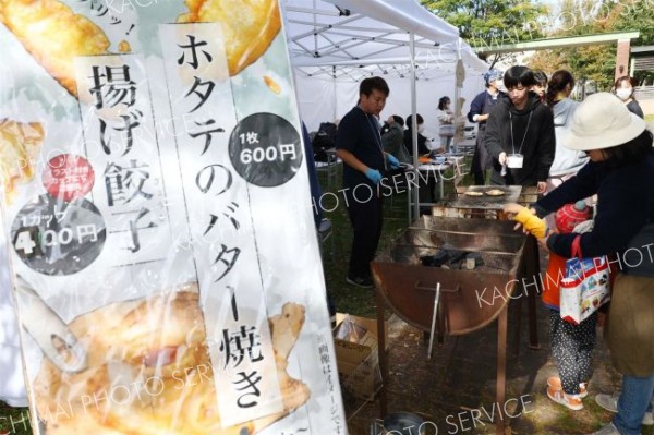 ホタテのバター焼きや揚げ餃子を提供する、畜大と小樽商大、北見工大の実行委（助川かおる通信員撮影）
