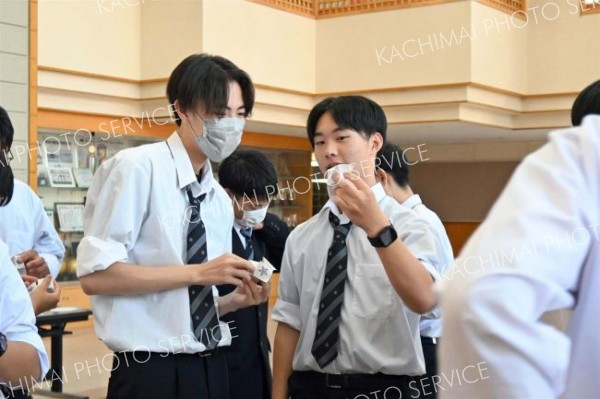 折り紙に書いた自分の良いところを相手に紹介し合う生徒たち