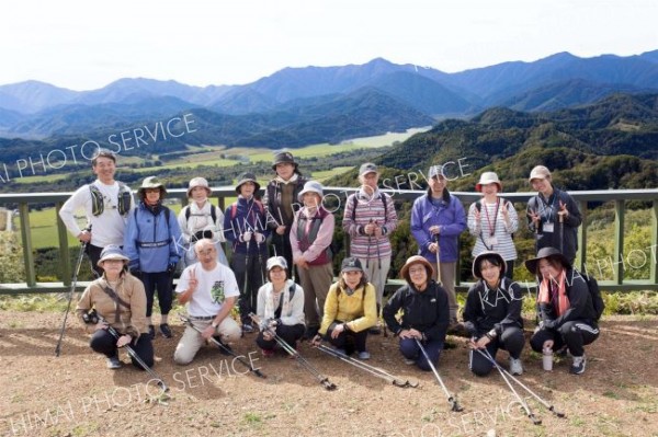 山頂展望台まで歩き、日高山脈の雄大な景色をバックに記念撮影する参加者ら