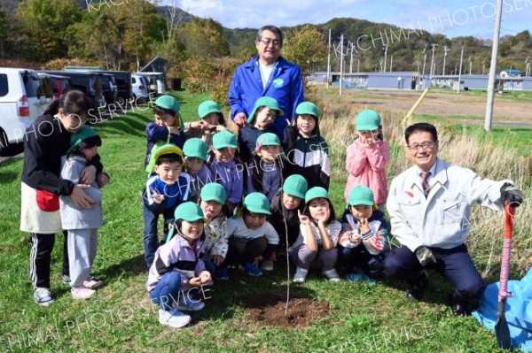 子どもたちと一緒に植樹セレモニーを行った山田支店長（最後列）と田中町長（右）