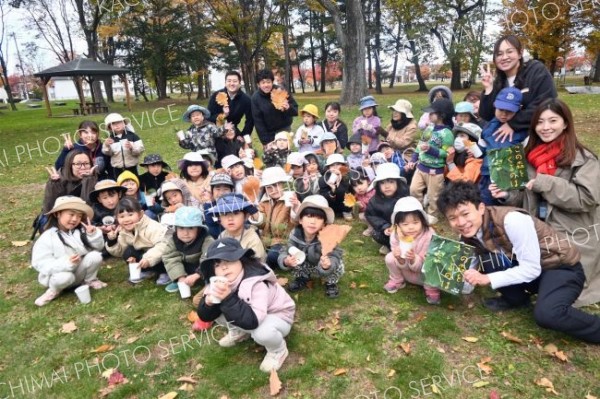 宝探し終了後、写真絵本などを抱え記念撮影する園児ら