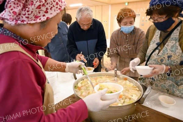 取れたての新鮮野菜を使った豚汁を器によそう地域住民ら