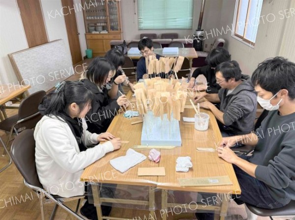 説明を受けながらうろこを作る参加者