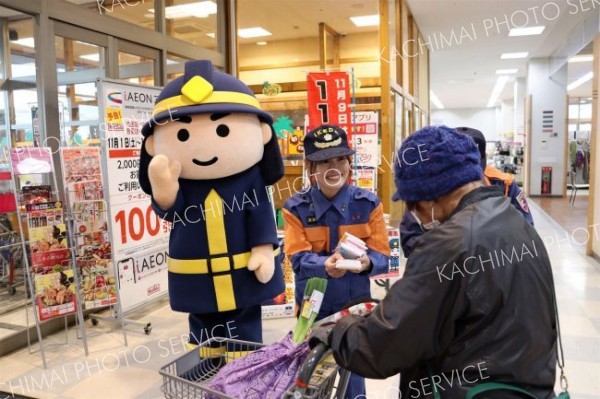 買い物客に火災予防を呼び掛ける消防団員