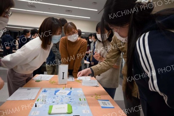 真剣な様子でボードゲームに取り組む医療従事者ら