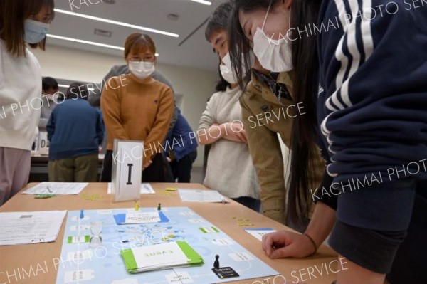 真剣な様子でボードゲームに取り組む医療従事者ら